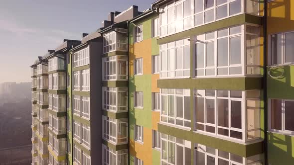 Aerial footage of a tall residential apartment building with many windows and balconies.