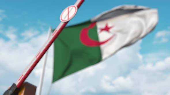 Barrier with STOP CORONAVIRUS Sign Closed at Flag of Algeria
