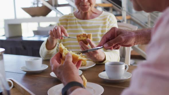 Senior caucasian couple having talking to each while having breakfast together at home