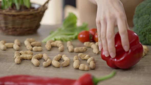 Almond Nuts Saying Healthy Food and Female Hand Putting Bell Pepper on Table Closeup