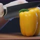 Person in White Gloves Cuts Yellow Bell Pepper with Knife - VideoHive Item for Sale