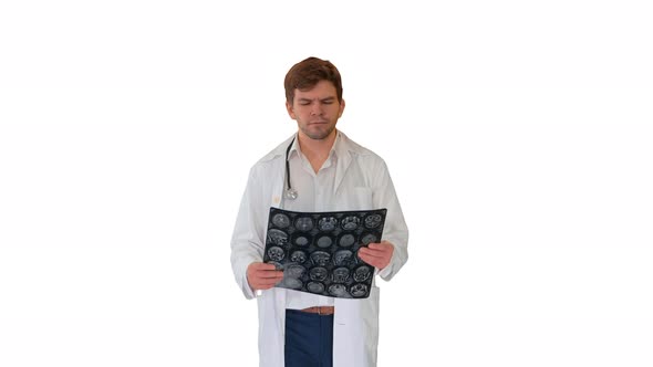 Concentrated Male Doctor Examining Computed Tomography While Walking on White Background.