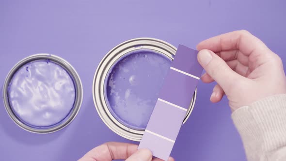 Close up of metal paint can with purple paint and paint swatch.