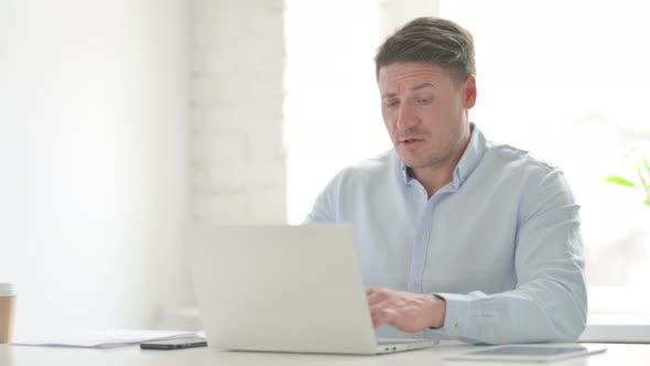 Man having Wrist Pain while using Laptop in Office