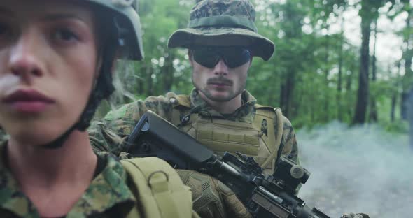 Squad of Soldiers Patrolling Across the Forest Area Team with Male and Female Soliders in Dense