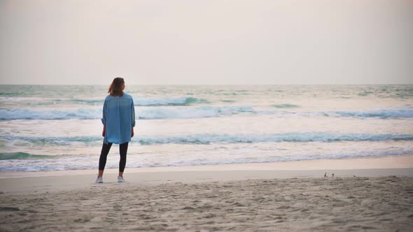 Woman Standing at the Beach and Enjoying the Sea View.