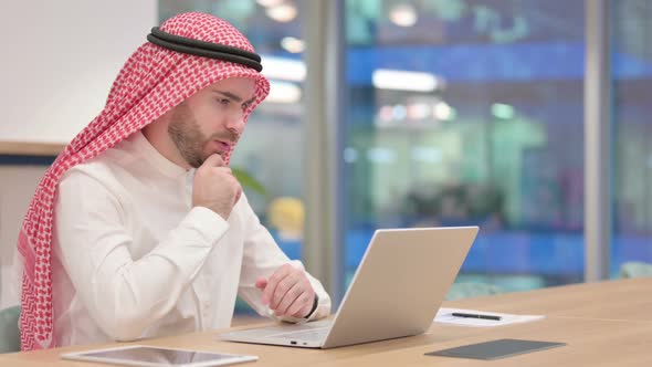 Thoughtful Arab Businessman Thinking and Working on Laptop in Office 