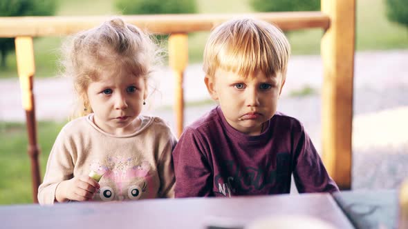 Close-up: Children Sit in the Summer House and Eat. Mom Feeds Them with Vegetables