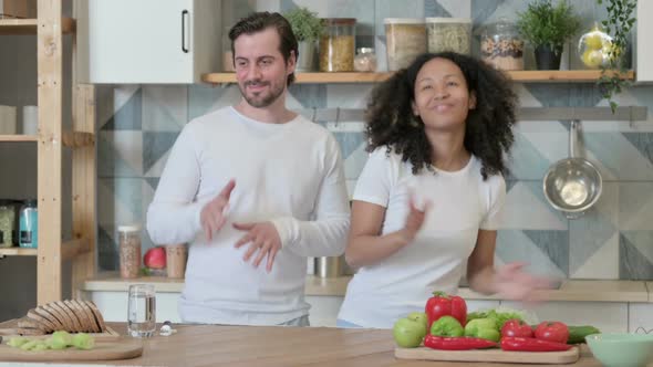 Mixed Race Couple Dancing in Kitchen