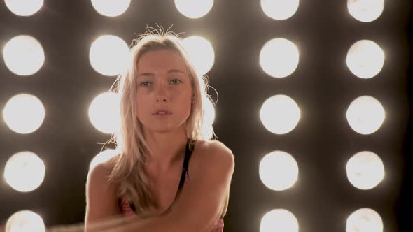 Beautiful Woman Working Out In Front Of A Wall Of Lights