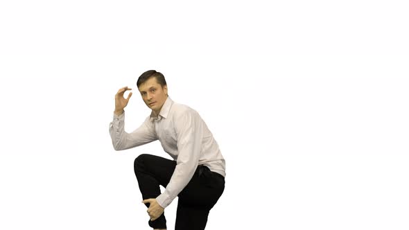 Young Man Dressed in White Shirt and Black Pants Dancing Break Dance on White Background