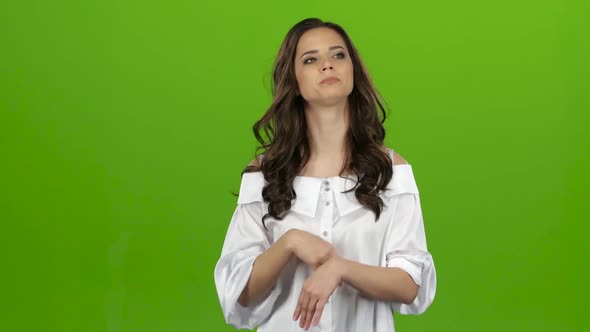 Girl Worries Bites Her Lip and Nervously Corrects Her Hair. Green Screen