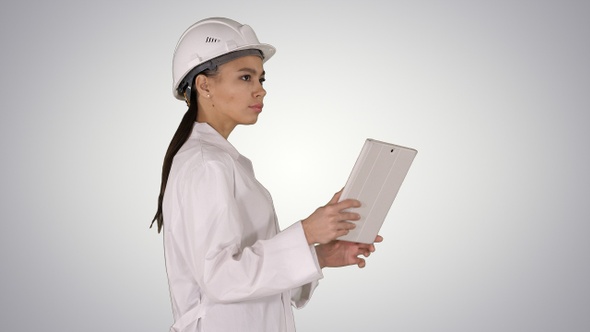 Young Woman Engineer Walking with Tablet Looking at Objects