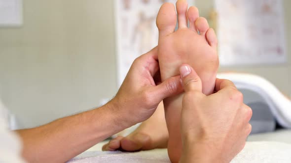 Physiotherapist giving foot massage to a woman