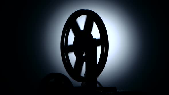 Silhouette in a Dark Studio. Bobbin Movie Projector Reels Film