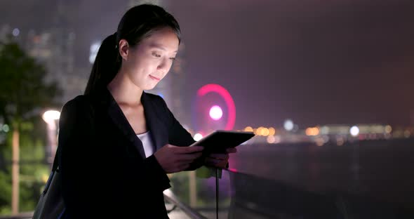 Business woman use of tablet computer at night