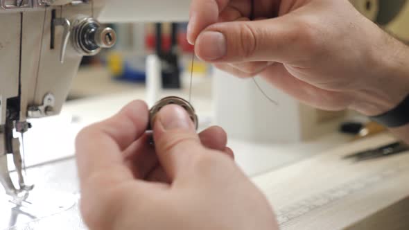 Male Hands Preparing Sewing Machine for Use in Private Craft Leather Studio. Man Puts Shuttle with