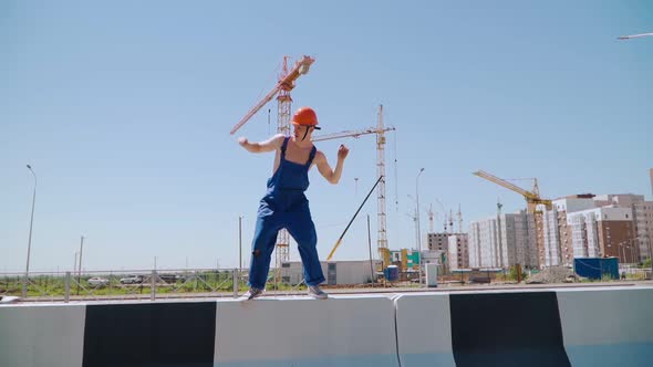 Happy Caucasian Man Builder in Hard Hat Dancing. Worker Funny Moves Background Construction Site.