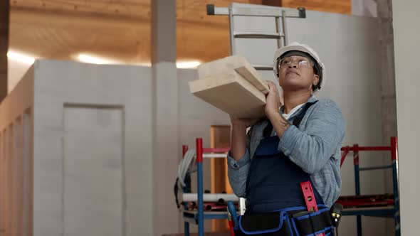 Worker Carrying Wooden Beams