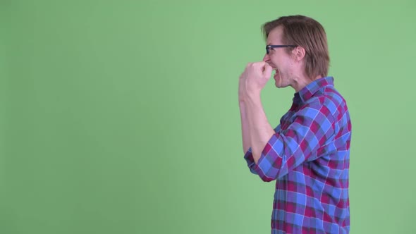 Profile View of Happy Young Hipster Man with Fists Raised