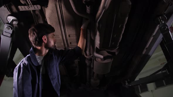 Repairman Checking Transmission Under Car Bottom