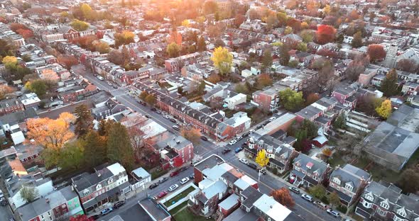Cinematic high aerial establishing shot of American city. Town in suburbs during magic hour sunrise.