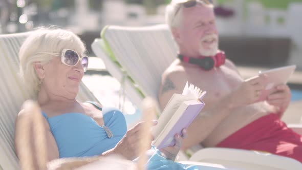 Cute Couple Lying on Sunbeds Near the Pool