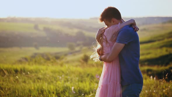 A Young Beautiful Couple Hug and Kiss, Nature, Field at Sunset