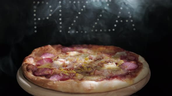 Delicious Fresh Italian Pizza On A Black Background With The Effect Of Light Inscription Pizza