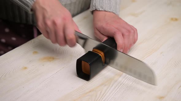 woman turning a knife in the kitchen