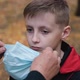 Grandmother Helps Puts a Medical Mask on the Face of Her Grandson - VideoHive Item for Sale