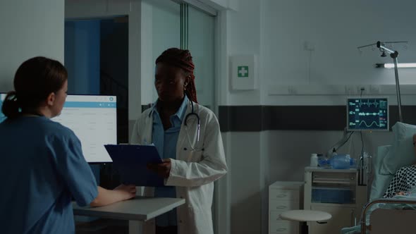 African American Doctor Checking Tests for Sick Patient