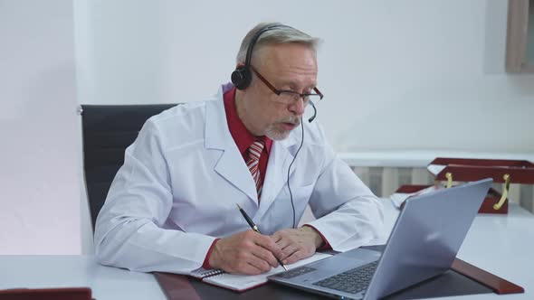 Doctor wear headset who is listening to patient and then talking about his symptom online. 