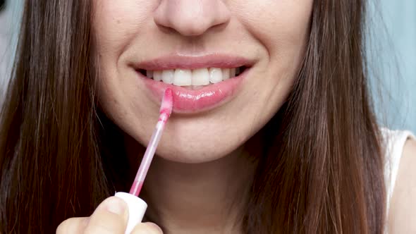 close up 4k video with woman smiling and painting lips with red color lipstick. morning make up conc