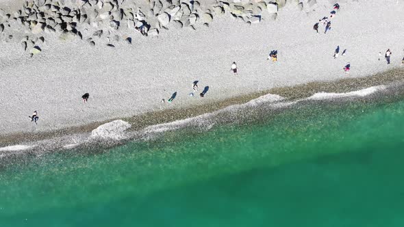 Aerial View of People Crowd Relaxing on Beach and Sea with Waves. Top View From Flying Drone.