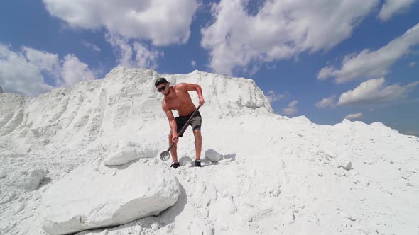 Man fitness training with large and heavy hammer. Young man with a hammer strike stone on nature