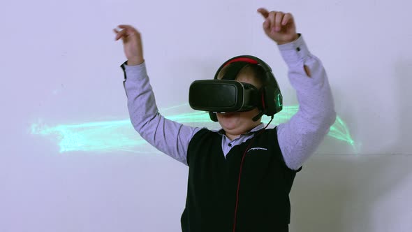 A Boy in Augmented Reality Headset and Headphones is Dancing While Standing