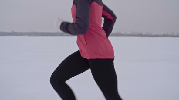 Athletic Woman Jogging in Snowy Countryside