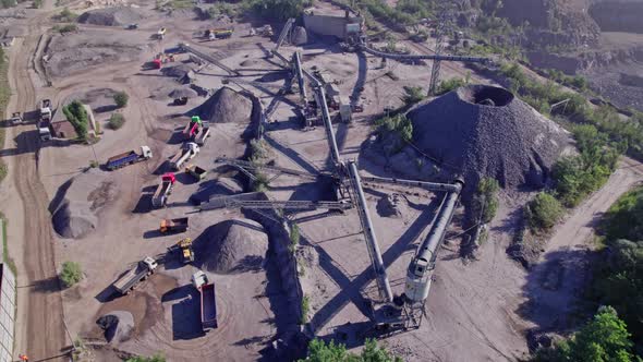 Excavators and Tractors Load Crushed Stone and Rock Into Dump Trucks