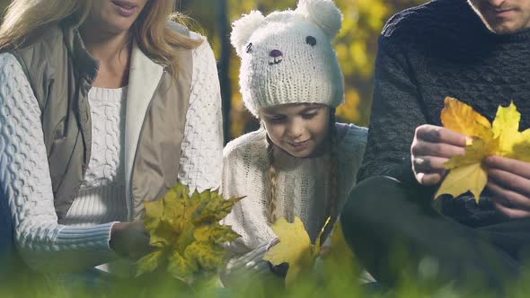 Parents Playing With Daughter in Autumn Forest, Joking and Having Fun Together