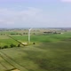 Drone Shot Flying Towards Large Wind Turbine in Open Green Fields - VideoHive Item for Sale