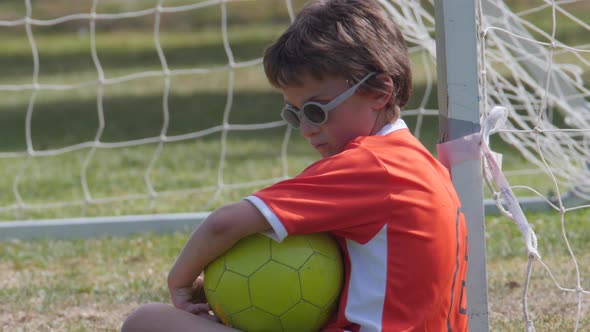Young boy soccer player posing by the goal.