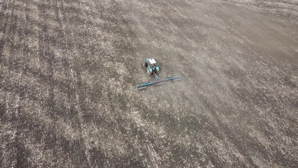 Farmer on a tractor plows the field.