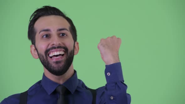 Face of Happy Young Bearded Persian Businessman Getting Good News