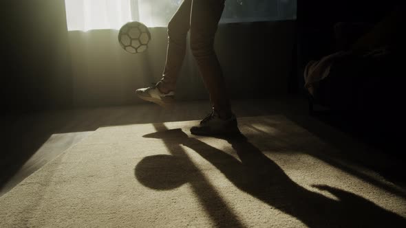 Man Minting a Soccer Ball Professional Football Player Training in the Living Room at Home or Office