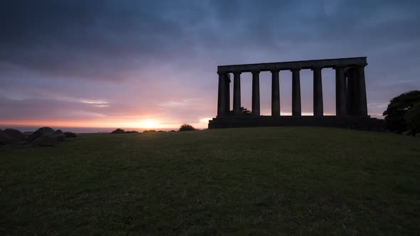 Timelapse of the sunrise near a monument alt