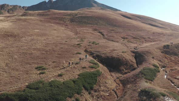 Aerial View Flight Group of Backpacker People Hiking on Natural Hilly Mountain Landscape Enjoy