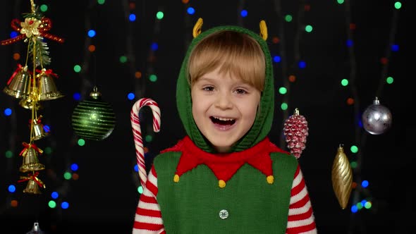 Girl in Christmas Elf Santa Helper Costume Waving Greeting with Hand