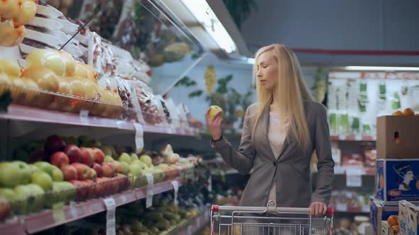 Beautiful Young Woman with Trolley Shopping in Supermarket