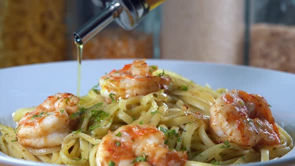 Close Shot of Extra Virgin Olive OIl Being Drizzled Over Shrimp and Pasta